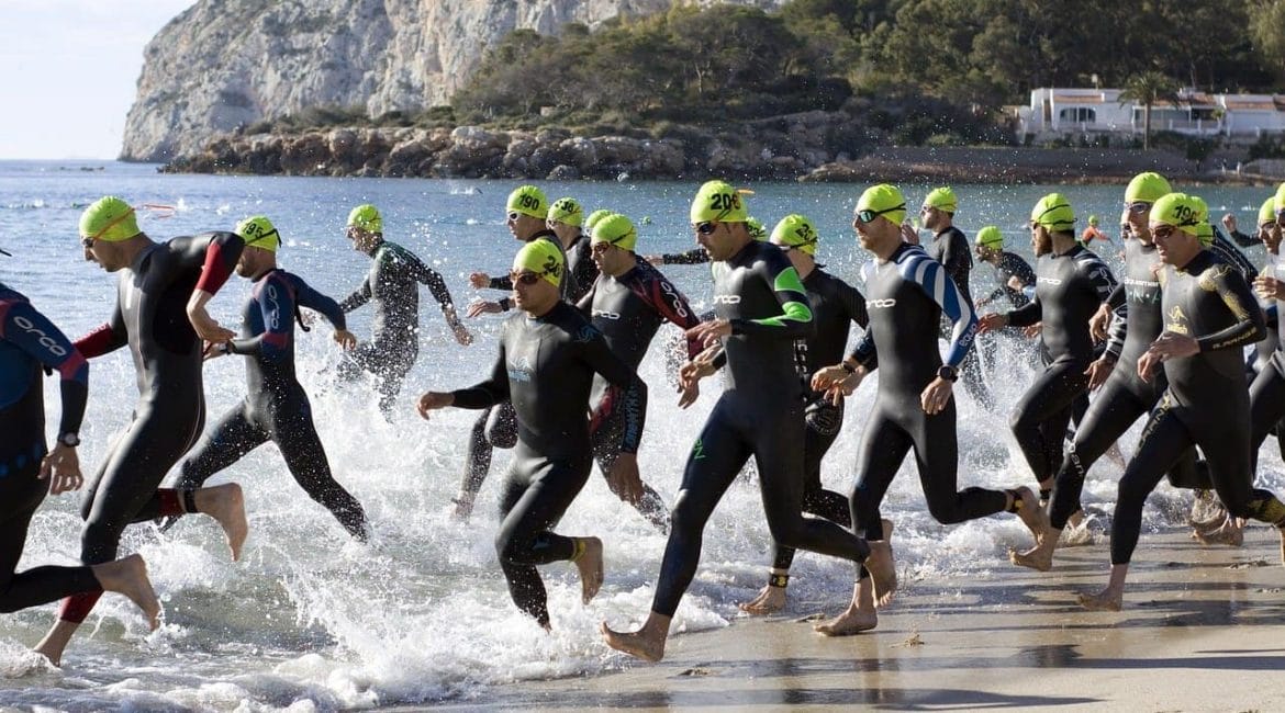 Triathletes running in open water